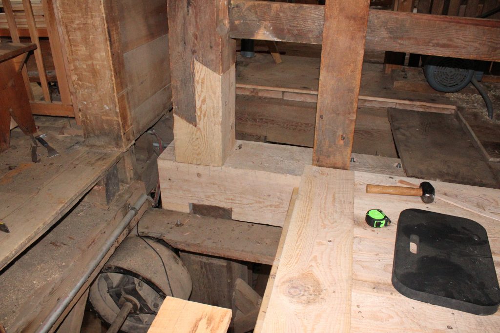 Wooden posts and beams in a historic, industrial building that have been restored using new wood from the site's sawmill.