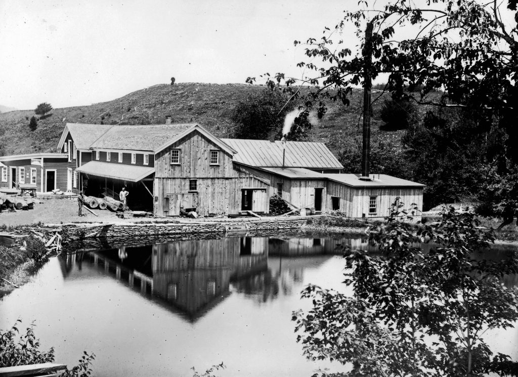 black and white historical image of the mill site shows the mill across the pond