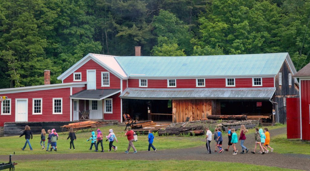 a group of children walk in front of the mill building